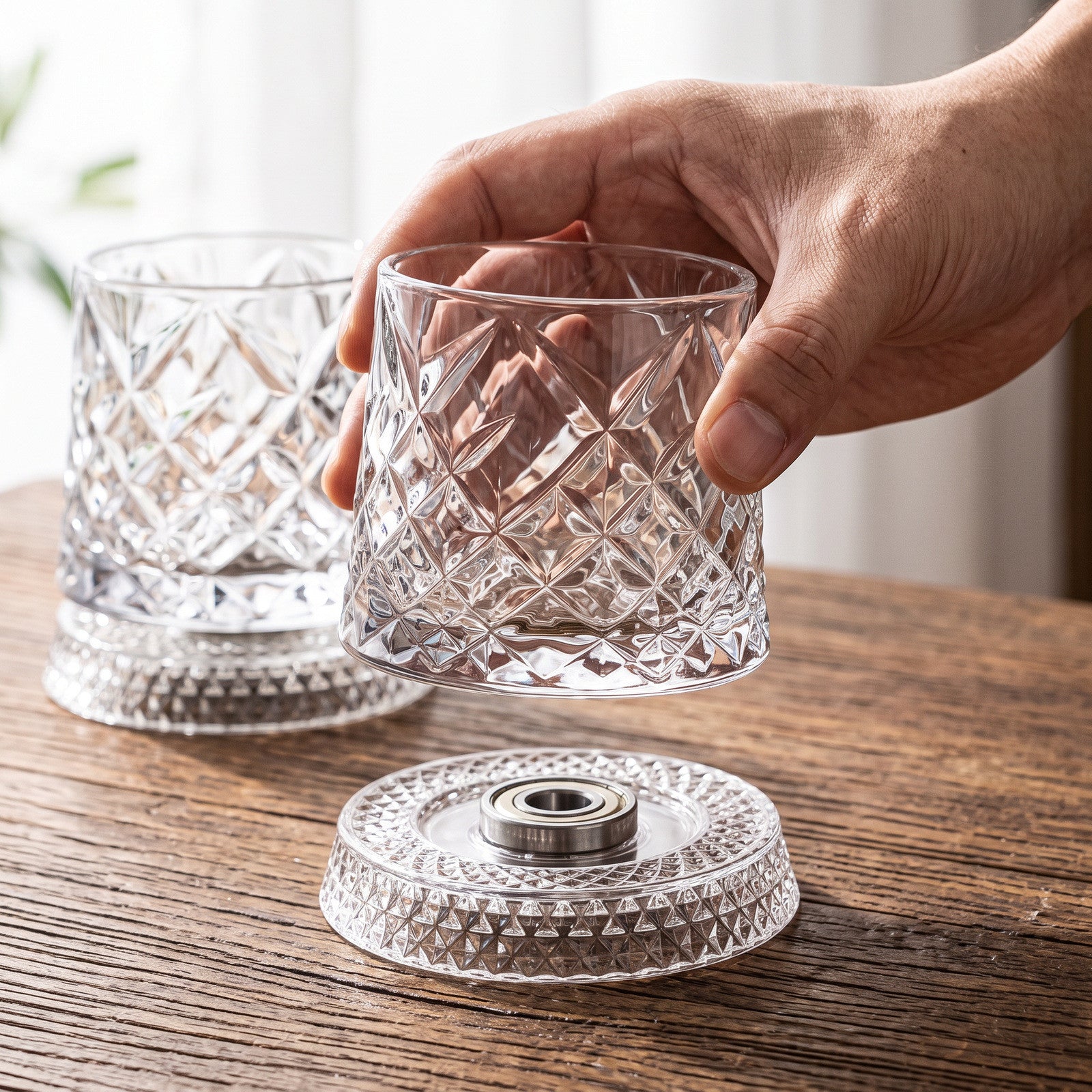 Hand holding a diamond glass above its base and steel bearing
