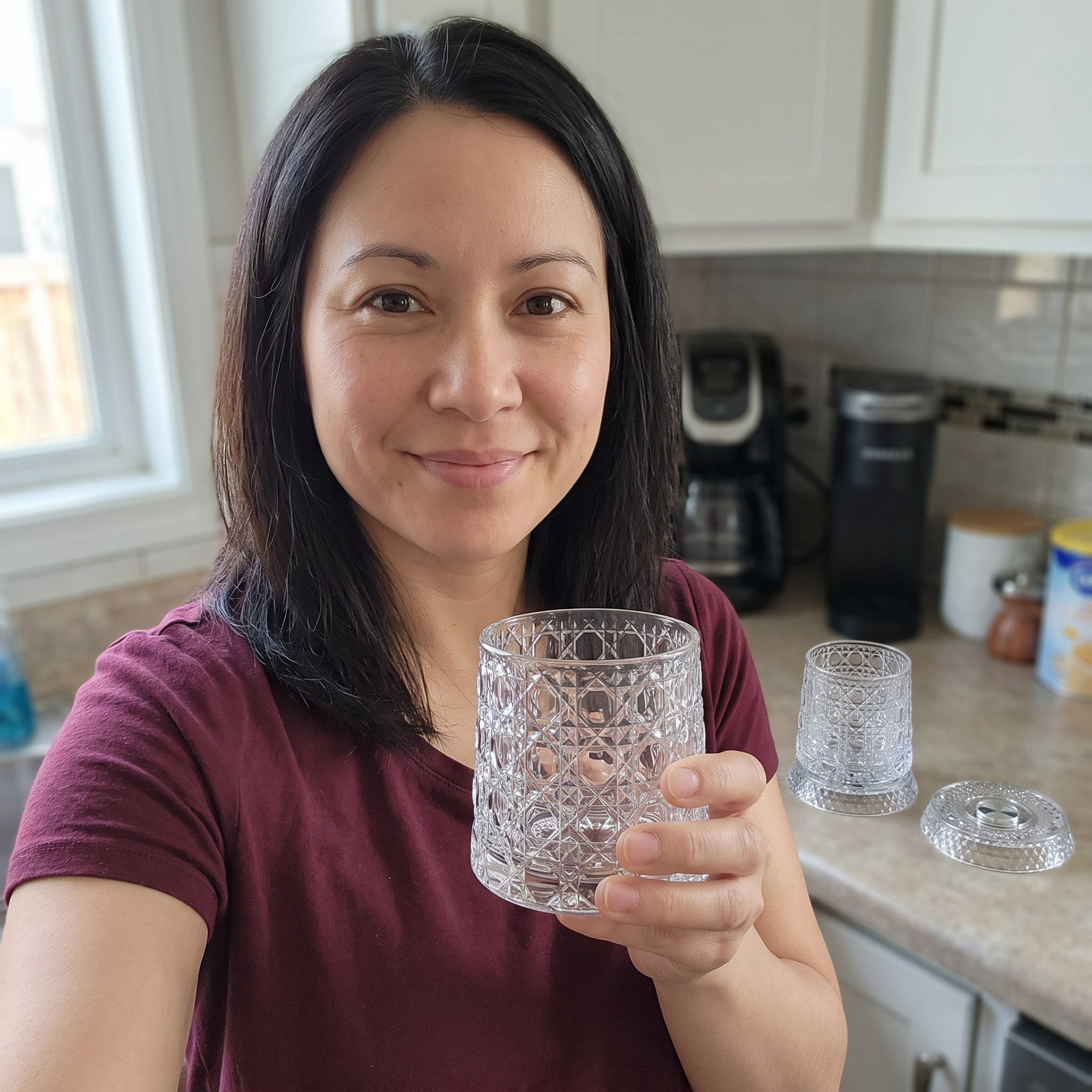 Woman holding a scallop glass in her kitchen, with its companion and bases behind
